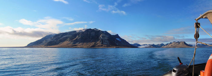 Scenic view of sea and mountains against sky