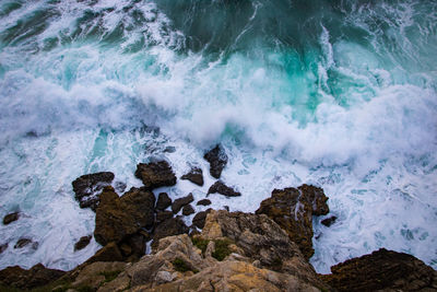 High angle view of waves breaking on rocks