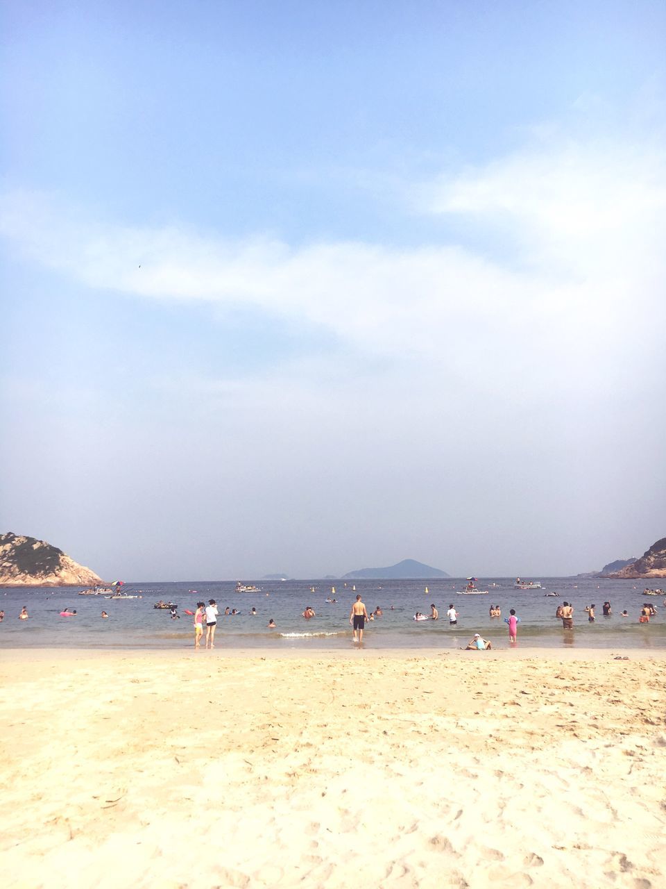 beach, sand, sea, shore, water, sky, large group of people, vacations, leisure activity, lifestyles, scenics, tranquil scene, tranquility, tourist, mixed age range, beauty in nature, horizon over water, nature, tourism, cloud - sky, enjoyment, coastline, summer, day, cloud, idyllic, outdoors, travel destinations, blue
