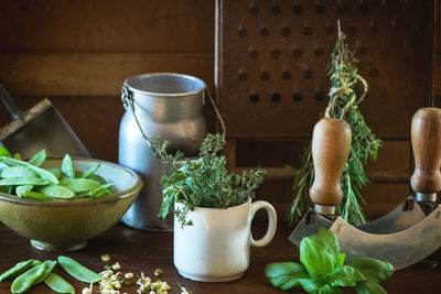 Vegetables and herbs with cooking utensils on table