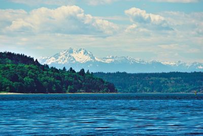 Scenic view of lake by mountains against sky