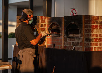 Man wearing mask preparing food at home