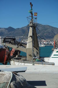 Ship moored at harbor against clear sky