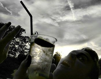 Low angle view of wine glass against cloudy sky