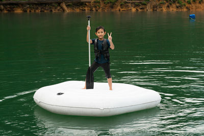 Man holding boat in lake