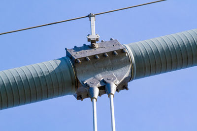 Low angle view of telephone pole against clear blue sky