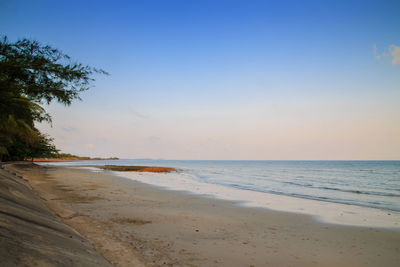 Scenic view of beach against clear sky during sunset