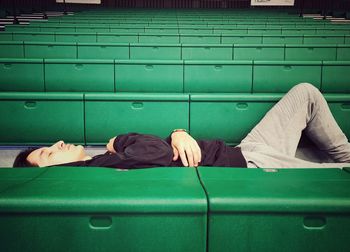 Man sleeping on green seat