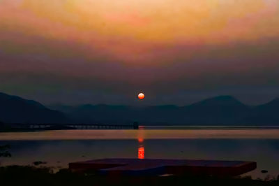 Scenic view of lake against romantic sky at sunset