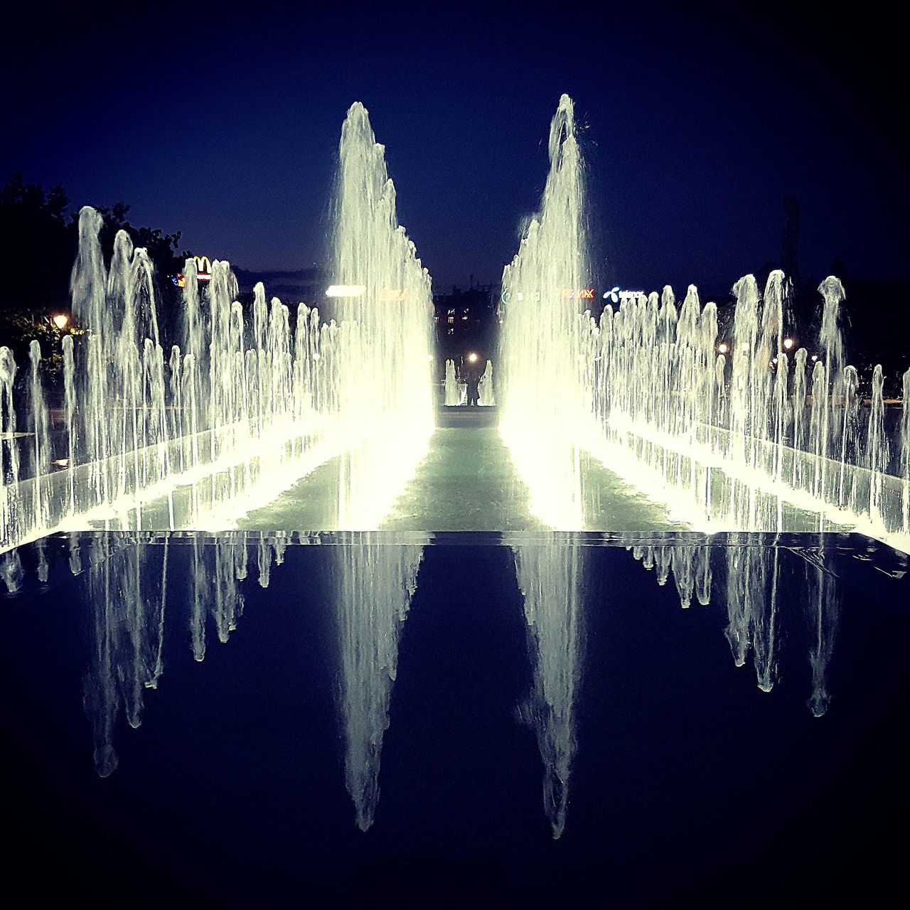 fountain, water, spraying, famous place, night, motion, travel destinations, tourism, sky, flowing water, outdoors, nature, illuminated, no people, blue, scenics, beauty in nature, weather