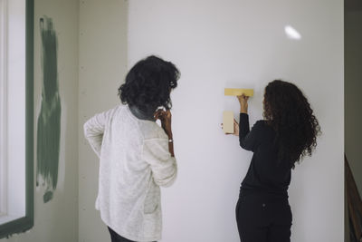 Side view of mother and daughter at home