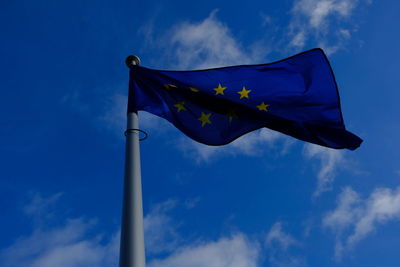 Low angle view of flag against blue sky