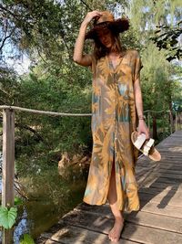 Full length of woman standing against plants