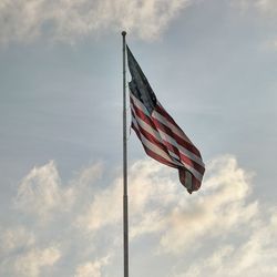 Low angle view of american flag against blue sky