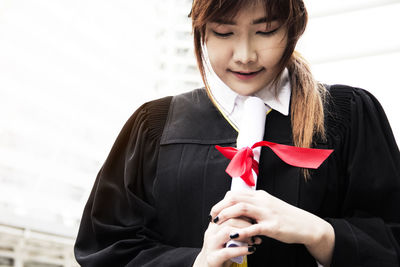 Young woman standing against building