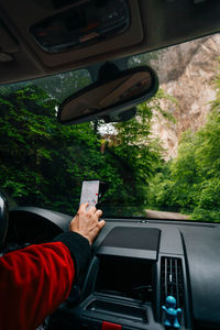 Man driving and using gps on his smartphone on mountain road