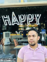 Portrait of young man standing in cafe