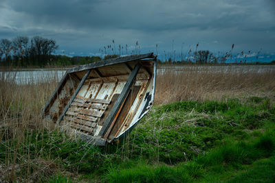 Old wrecked boat on the shore of the lake and storm clouds