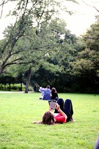 People relaxing on grassy field in park