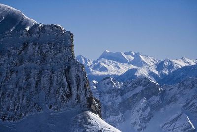 Scenic view of snowcapped mountains against clear blue sky