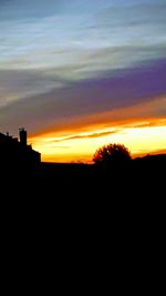 Silhouette landscape against dramatic sky during sunset