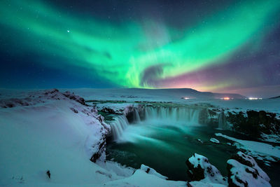 Scenic view of snowcapped mountains against sky at night