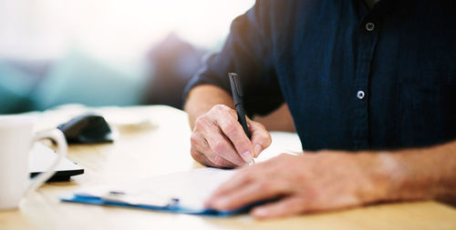 Midsection of businessman working on table