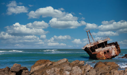 Sailboat on sea shore against sky