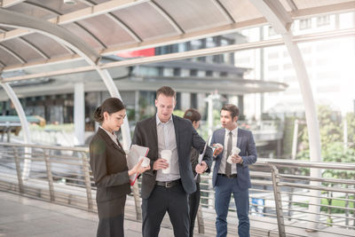 Business people discussing while standing on elevated walkway