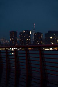 Illuminated city buildings against clear sky at dusk