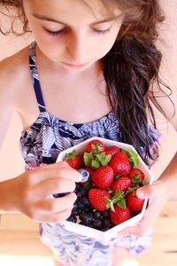 Girl holding bowl with strawberries