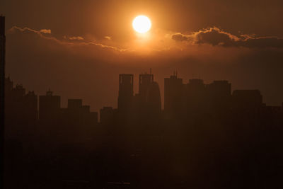 Silhouette buildings against sky during sunset