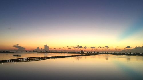 Scenic view of silhouette city against sky during sunset