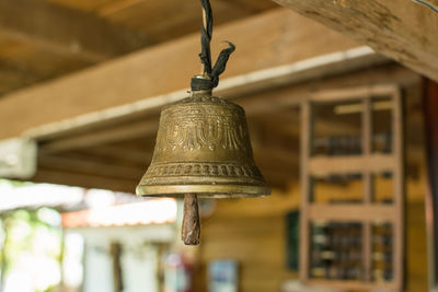 Low angle view of electric lamp hanging in old building