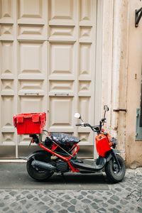 Motor scooter parked against building