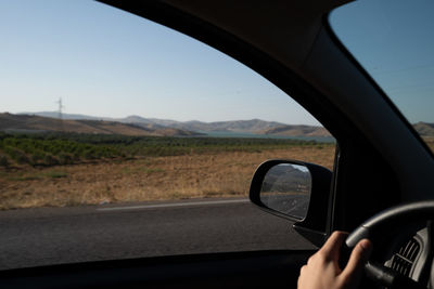 Man seen through car windshield