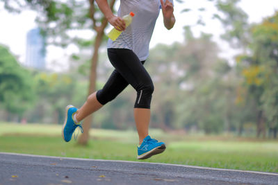 Low section of woman running on road