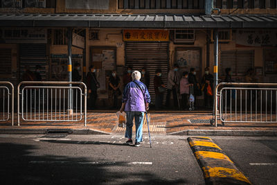 Full length rear view of man walking on road