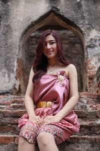 Portrait of a smiling young woman sitting outdoors