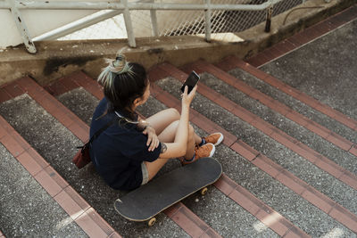 High angle view of woman using smart phone while sitting on steps