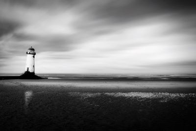 Lighthouse by sea against sky