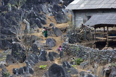 People on rocks amidst buildings