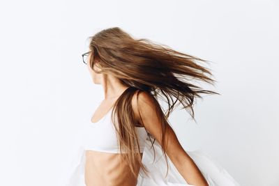 Rear view of woman standing against white background