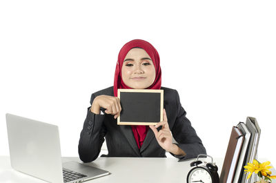 Portrait of young woman using smart phone against white background