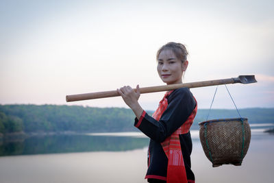 Young woman holding umbrella against clear sky