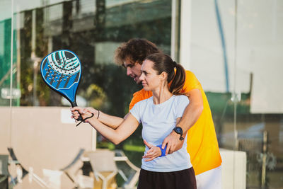 Man and woman holding tennis racket