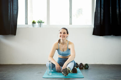 Portrait of smiling young woman sitting on floor