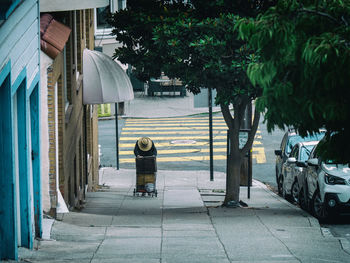 Rear view of man on street amidst buildings in city