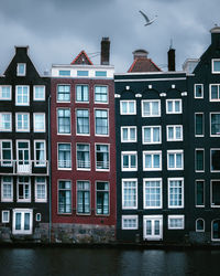 The unique houses of damrak on a cloudy day found in the heart of the dutch capital of amsterdam.