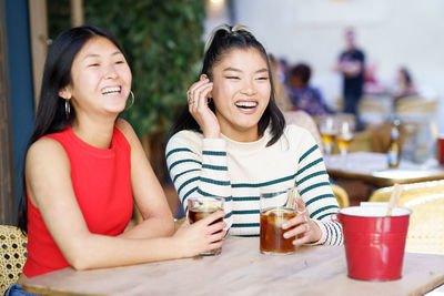 Portrait of smiling friends sitting at restaurant